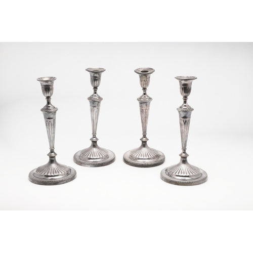 227 - A SET OF FOUR GEORGE III SILVER CANDLESTICKS. with corded borders, fluted decoration on the terminal... 