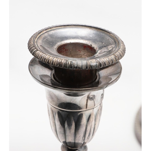 227 - A SET OF FOUR GEORGE III SILVER CANDLESTICKS. with corded borders, fluted decoration on the terminal... 