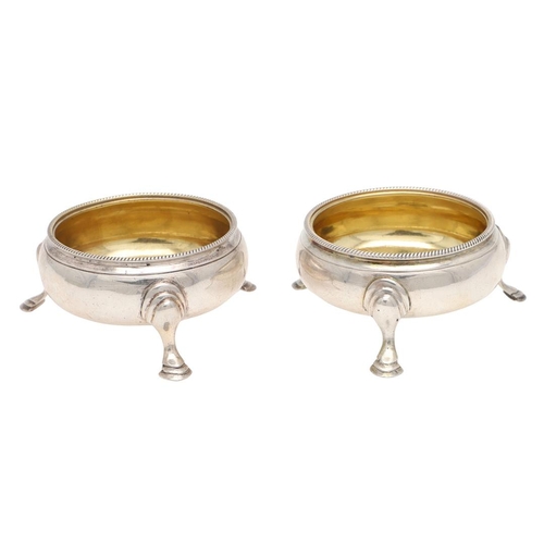 232 - A PAIR OF GEORGE III SQUAT CIRCULAR SILVER SALTS, BY HESTER BATEMAN. with corded borders and hoof fe... 