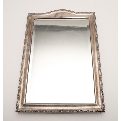 252 - AN EDWARDIAN SILVER MOUNTED MIRROR. shaped rectangular outline, with a scroll border, bevelled glass... 