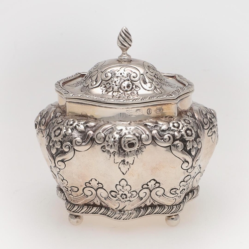 259 - A LATE VICTORIAN EMBOSSED SILVER TEA CADDY. bombÃé form, with a wrythen finial, ball feet & a gilt i... 