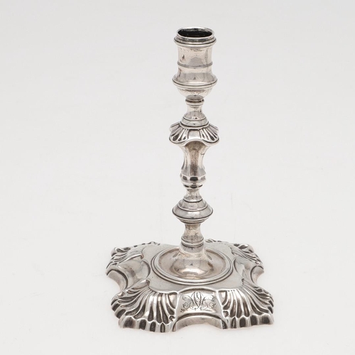 274 - A GEORGE II CAST SILVER TAPERSTICK. on a shaped square base, with shell decoration, a knopped stem a... 