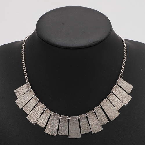 290 - A CASED MODERN, WEST-COUNTRY SILVER NECKLACE. with fifteen alternating textured panels, by Christoph... 