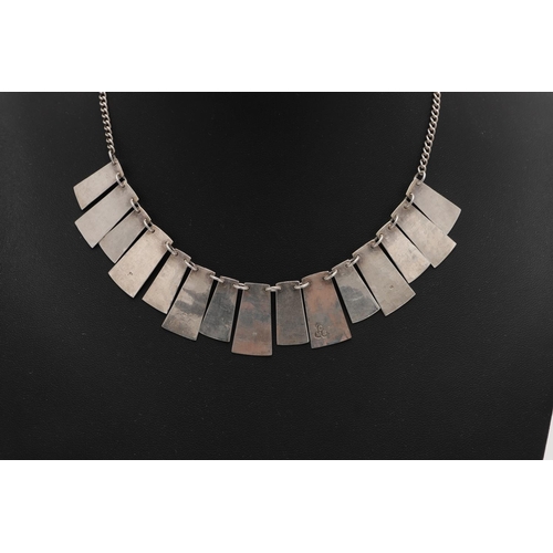 290 - A CASED MODERN, WEST-COUNTRY SILVER NECKLACE. with fifteen alternating textured panels, by Christoph... 