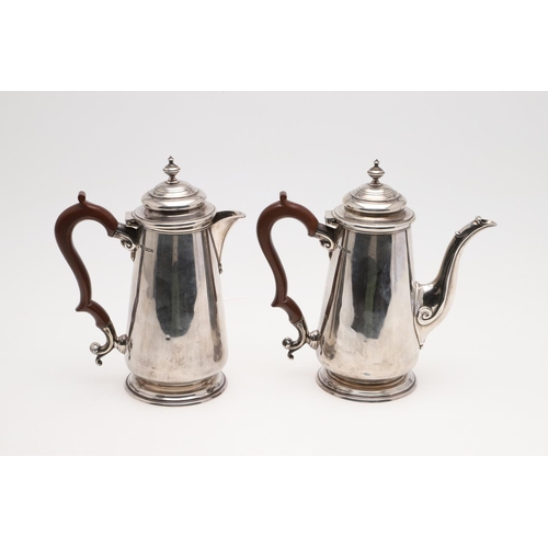 93 - A PAIR OF GEORGE V TAPERING SILVER CAFE AU LAIT POTS. with domed covers, knop finials and scroll han... 