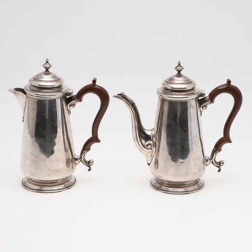 93 - A PAIR OF GEORGE V TAPERING SILVER CAFE AU LAIT POTS. with domed covers, knop finials and scroll han... 