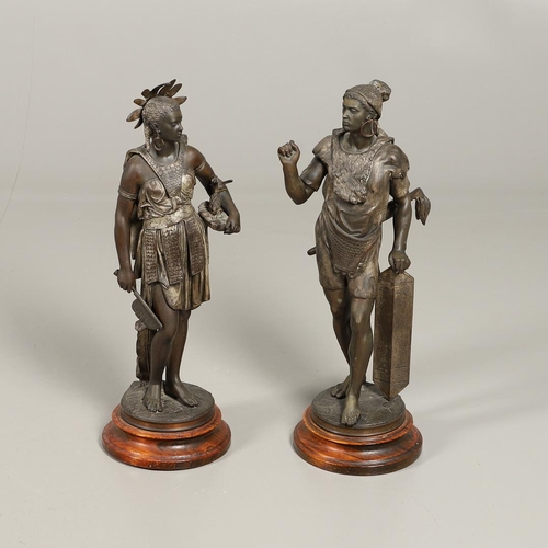 1173 - A PAIR OF BRONZED METAL WEST INDIAN/CARIBBEAN FIGURES. 20th century, each in tribal attire with feat... 