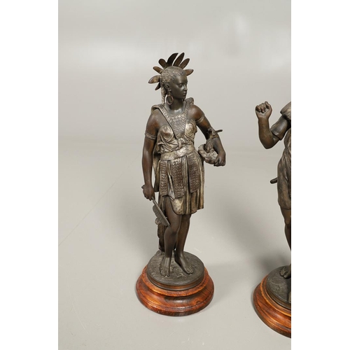 1173 - A PAIR OF BRONZED METAL WEST INDIAN/CARIBBEAN FIGURES. 20th century, each in tribal attire with feat... 