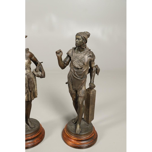 1173 - A PAIR OF BRONZED METAL WEST INDIAN/CARIBBEAN FIGURES. 20th century, each in tribal attire with feat... 