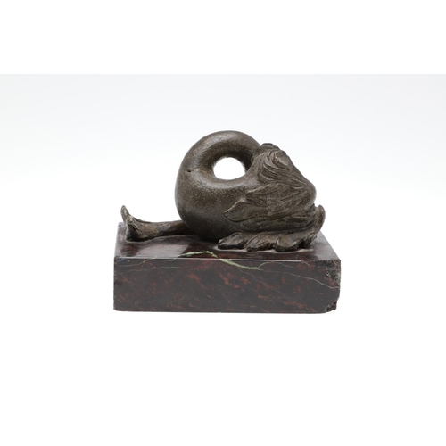 1192 - A 16TH CENTURY STYLE SERPENTINE MARBLE DESK WEIGHT. modelled as a mythical dolphin upon a mottled de... 