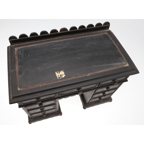 1194 - A PAINTED MINIATURE KNEEHOLE DESK. with carved gallery and an arrangement of nine drawers, height 35... 