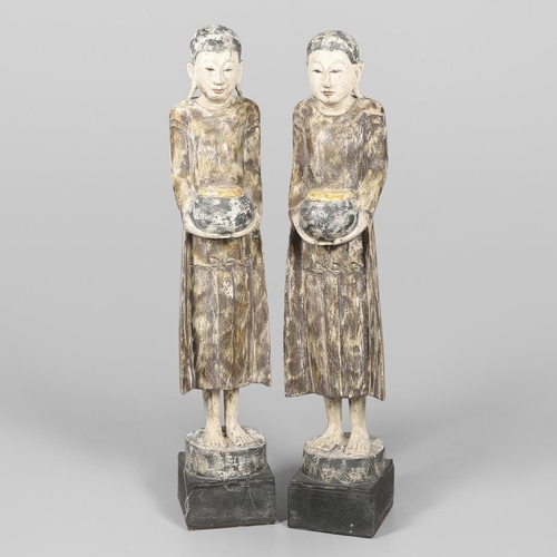 1203 - A PAIR OF THAI POLYCHROME CARVED STANDING WOODEN FIGURES OF MONKS. 20th century, each holding an off... 