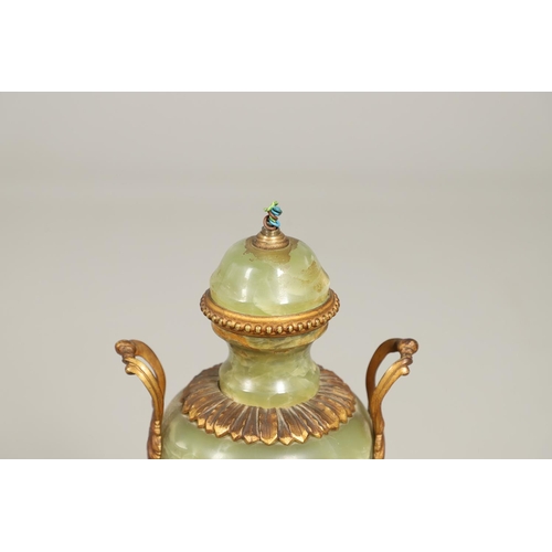 1205 - AN ONYX AND GILT METAL TABLE LAMP. of two handled Classical urn form with gilt metal leaf, floral an... 