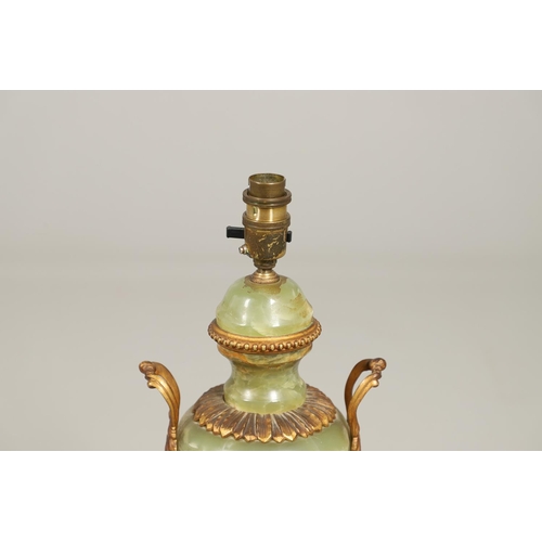 1205 - AN ONYX AND GILT METAL TABLE LAMP. of two handled Classical urn form with gilt metal leaf, floral an... 