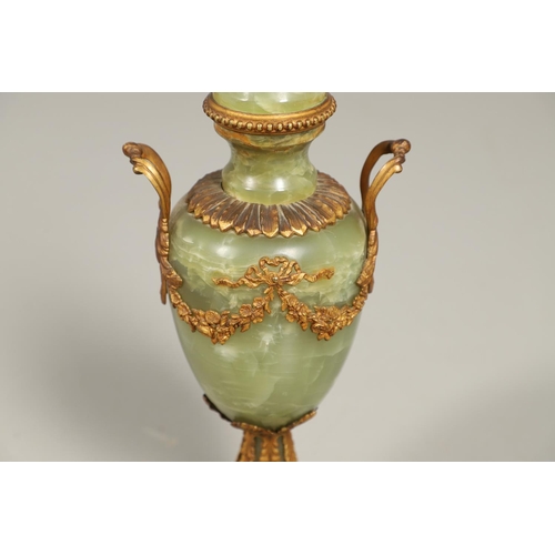 1205 - AN ONYX AND GILT METAL TABLE LAMP. of two handled Classical urn form with gilt metal leaf, floral an... 