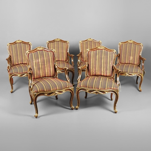 1212 - A SET OF SIX ITALIAN WALNUT AND PARCEL GILT OPEN ARMCHAIRS. by the contemporary designer and craftsm... 