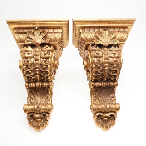 1213 - A PAIR OF 20TH CENTURY CARVED GILTWOOD WALL BRACKETS. each with stepped square shelves above heavily... 