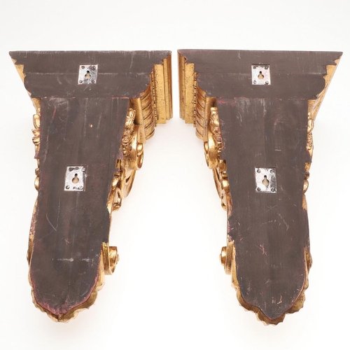 1213 - A PAIR OF 20TH CENTURY CARVED GILTWOOD WALL BRACKETS. each with stepped square shelves above heavily... 