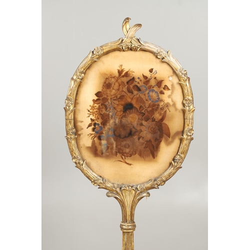 1220 - A 19TH CENTURY GILTWOOD POLE SCREEN. the oval floral silkwork panel within a carved naturalistic fra... 