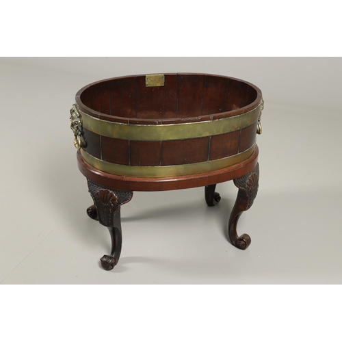 1253 - A GEORGE III BRASS BOUND MAHOGANY WINE COOLER. possibly Irish, of oval shape with finely cast lion m... 