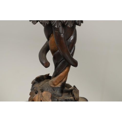 1256 - A PAIR OF PAINTED BLACKAMOOR TORCHERE STANDS. each carved figure holding aloft a shaped stand upon s... 