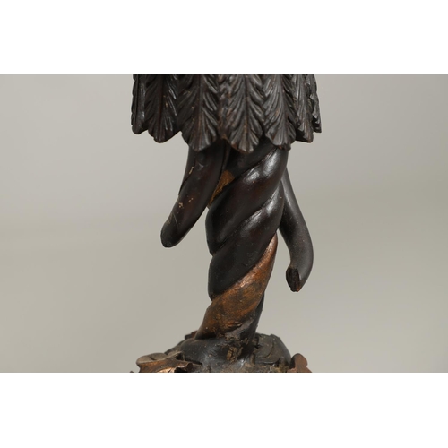 1256 - A PAIR OF PAINTED BLACKAMOOR TORCHERE STANDS. each carved figure holding aloft a shaped stand upon s... 