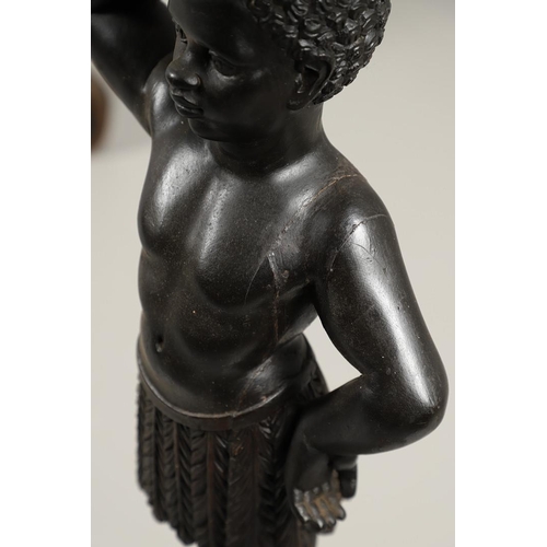 1256 - A PAIR OF PAINTED BLACKAMOOR TORCHERE STANDS. each carved figure holding aloft a shaped stand upon s... 