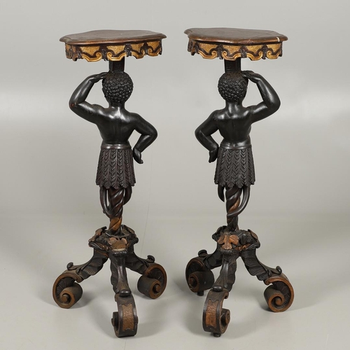 1256 - A PAIR OF PAINTED BLACKAMOOR TORCHERE STANDS. each carved figure holding aloft a shaped stand upon s... 