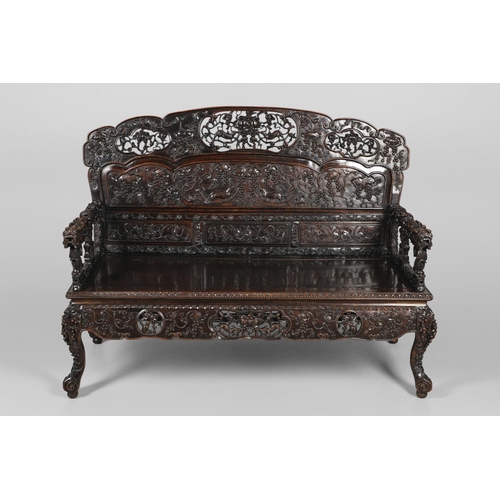 1267 - A CHINESE CARVED HARDWOOD HALL SEAT, QING DYNASTY, 19TH CENTURY. the shaped back with pierced triple... 