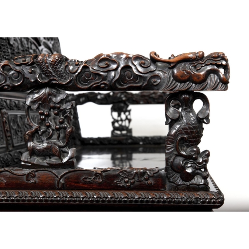 1267 - A CHINESE CARVED HARDWOOD HALL SEAT, QING DYNASTY, 19TH CENTURY. the shaped back with pierced triple... 