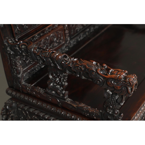 1267 - A CHINESE CARVED HARDWOOD HALL SEAT, QING DYNASTY, 19TH CENTURY. the shaped back with pierced triple... 