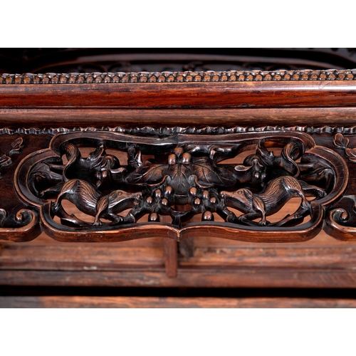 1267 - A CHINESE CARVED HARDWOOD HALL SEAT, QING DYNASTY, 19TH CENTURY. the shaped back with pierced triple... 