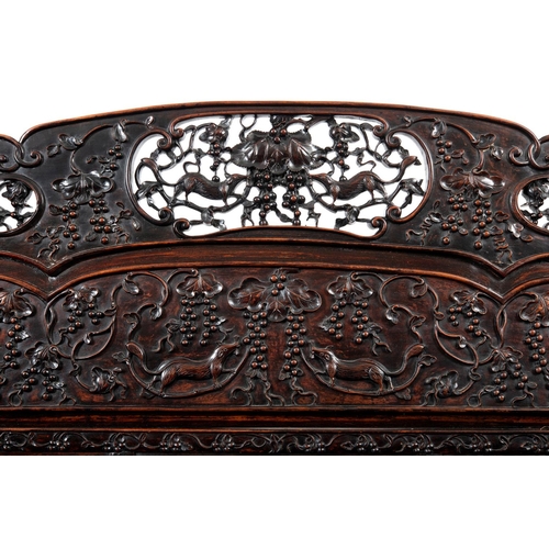 1267 - A CHINESE CARVED HARDWOOD HALL SEAT, QING DYNASTY, 19TH CENTURY. the shaped back with pierced triple... 