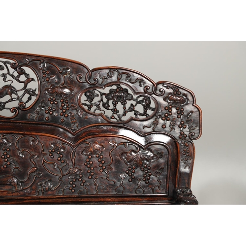 1267 - A CHINESE CARVED HARDWOOD HALL SEAT, QING DYNASTY, 19TH CENTURY. the shaped back with pierced triple... 