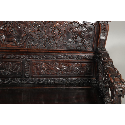 1267 - A CHINESE CARVED HARDWOOD HALL SEAT, QING DYNASTY, 19TH CENTURY. the shaped back with pierced triple... 