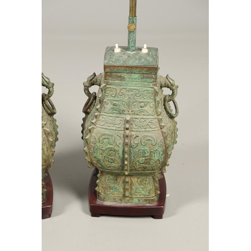 1271 - A PAIR OF CHINESE STYLE ARCHAIC BRONZE TABLE LAMPS. 20th century, with green painted 'patinated' fin... 