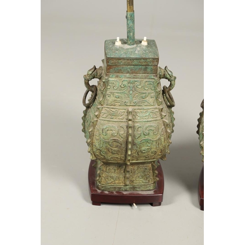 1271 - A PAIR OF CHINESE STYLE ARCHAIC BRONZE TABLE LAMPS. 20th century, with green painted 'patinated' fin... 