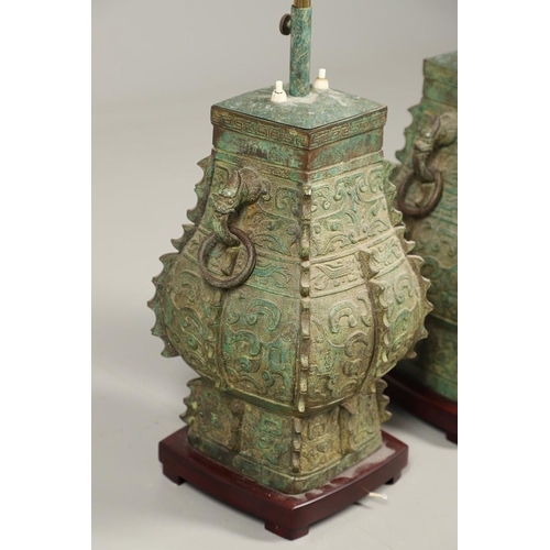 1271 - A PAIR OF CHINESE STYLE ARCHAIC BRONZE TABLE LAMPS. 20th century, with green painted 'patinated' fin... 