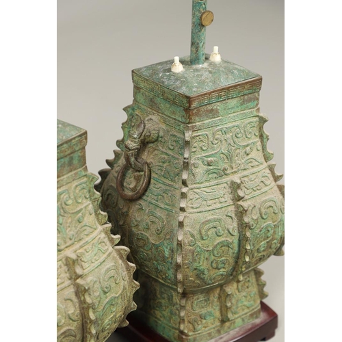 1271 - A PAIR OF CHINESE STYLE ARCHAIC BRONZE TABLE LAMPS. 20th century, with green painted 'patinated' fin... 