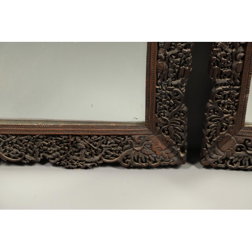 1272 - A PAIR OF EARLY 20TH CENTURY CHINESE CARVED WOODEN WALL MIRRORS. the frames carved and pierced with ... 