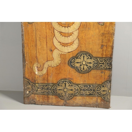 1274 - AN INDONESIAN PAINTED WOOD PANEL. decorated with the head of a blood thirsty demon and ornate 'strap... 