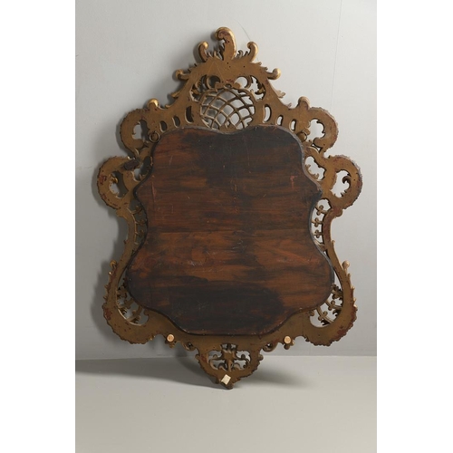 1291 - A 20TH CENTURY GILTWOOD WALL MIRROR. the heavily carved C scroll and foliate frame with a lattice an... 