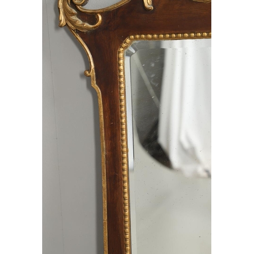 1294 - A GEORGE II STYLE WALNUT AND GILT GESSO WALL MIRROR. with gilt foliate scroll and cherub's head moun... 