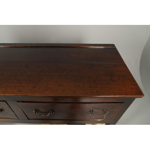 1300 - A GEORGE II OAK DRESSER BASE. the plank top over three drawers with brass handles and square legs, h... 