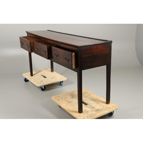 1300 - A GEORGE II OAK DRESSER BASE. the plank top over three drawers with brass handles and square legs, h... 