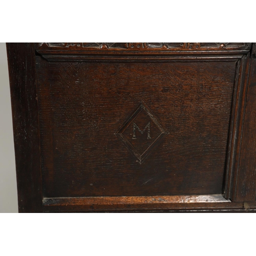 1306 - AN 18TH CENTURY OAK COFFER. the plain two plank top over a carved lunette frieze, the two panel fron... 