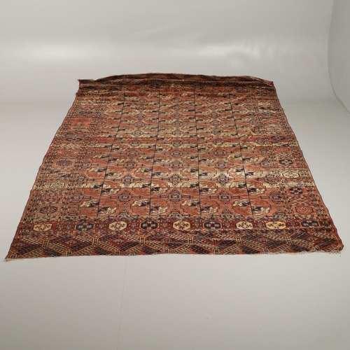 1312 - A TEKKE TURKMAN RUG, EMIRATE OF BUKHARA, CIRCA 1890. the madder field with four columns of guls encl... 