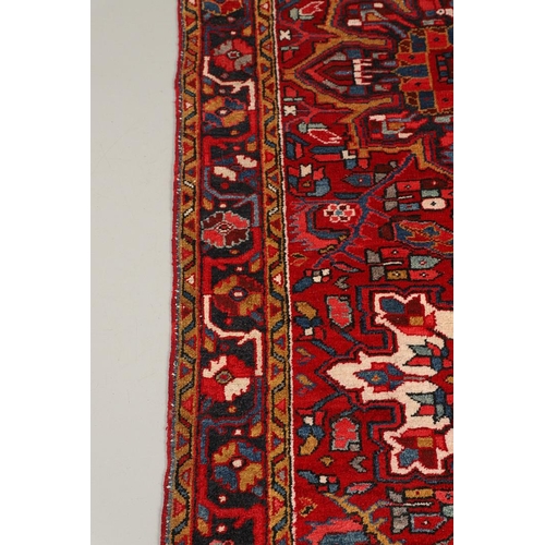 1315 - A HERIZ AHAR RUNNER, NORTH WEST PERSIA, CIRCA 1970. the deep brick red field with a column of large ... 