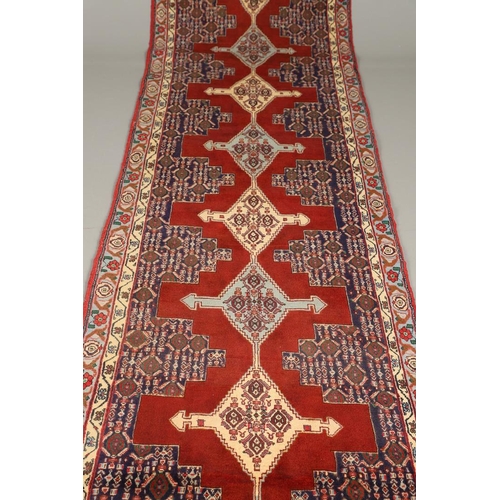 1318 - A SENNEH RUNNER, PERSIAN KURDISTAN, CIRCA 1980. the field with a column of winged diamond medallions... 