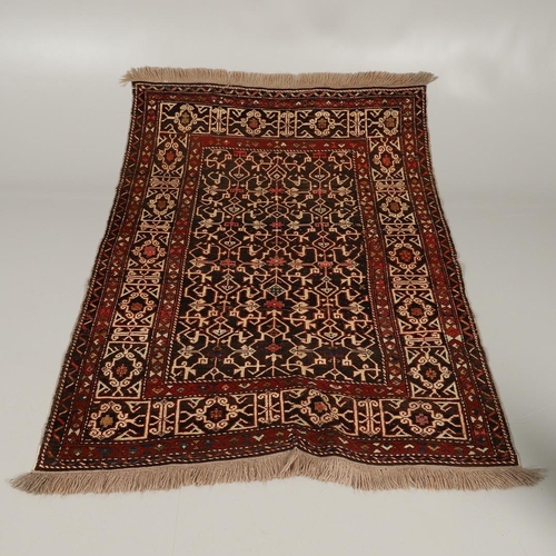 1321 - A KONAKEND RUG, NORTH EAST CAUCASUS, CIRCA 1900. the charcoal field of angular vines enclosed by Kuf... 